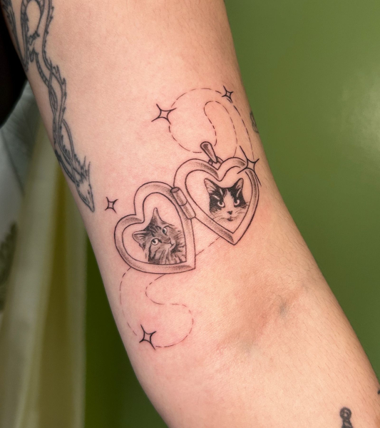 2026 tattoo trends cute locket tattoo with cat portraits on arm